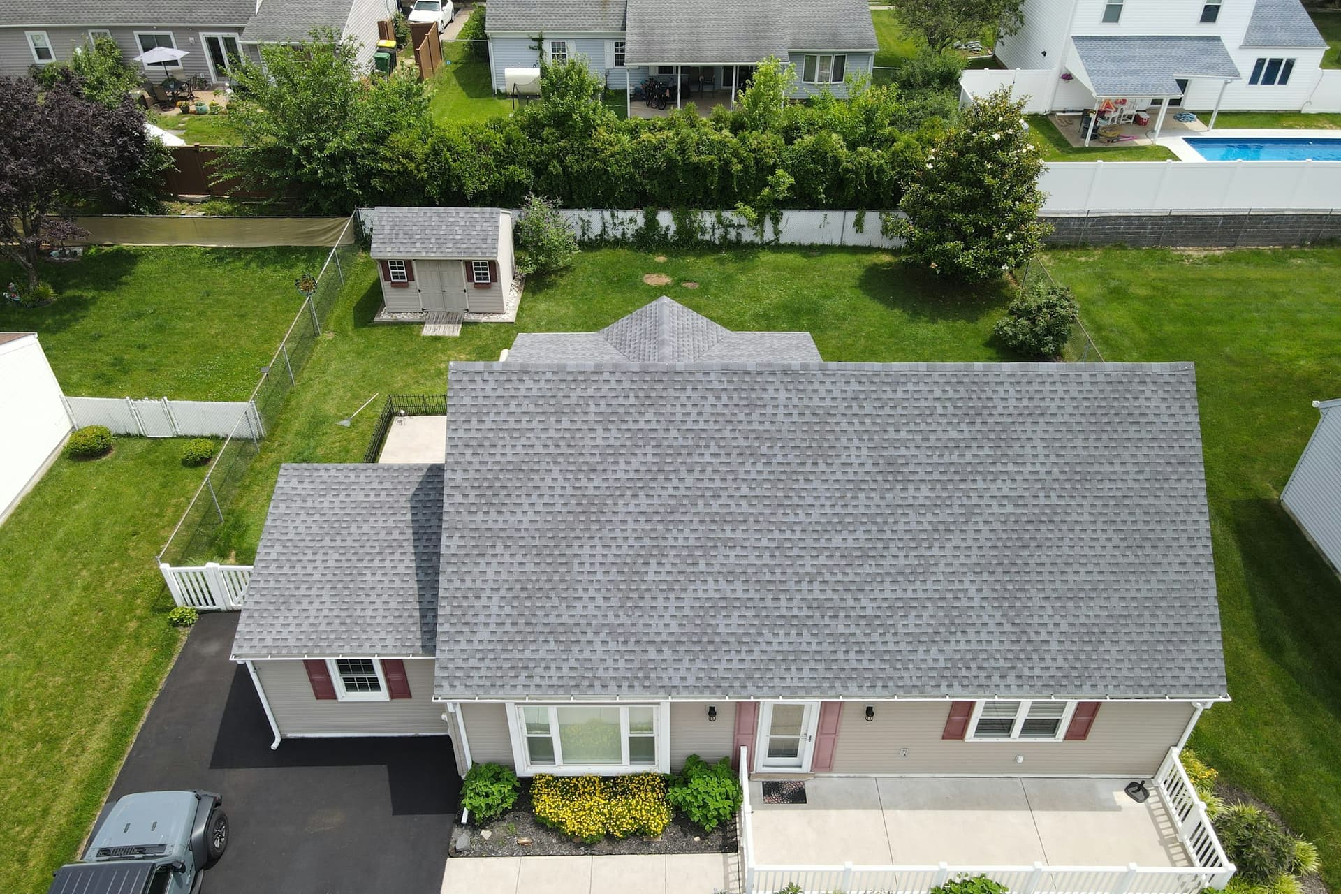 Drone view of a house with an asphalt shingle roof