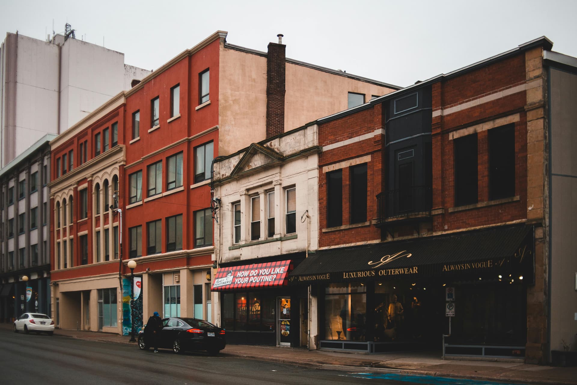 Row of older brick commercial storefronts with varying construction styles illustrating property valuation complexity in commercial insurance