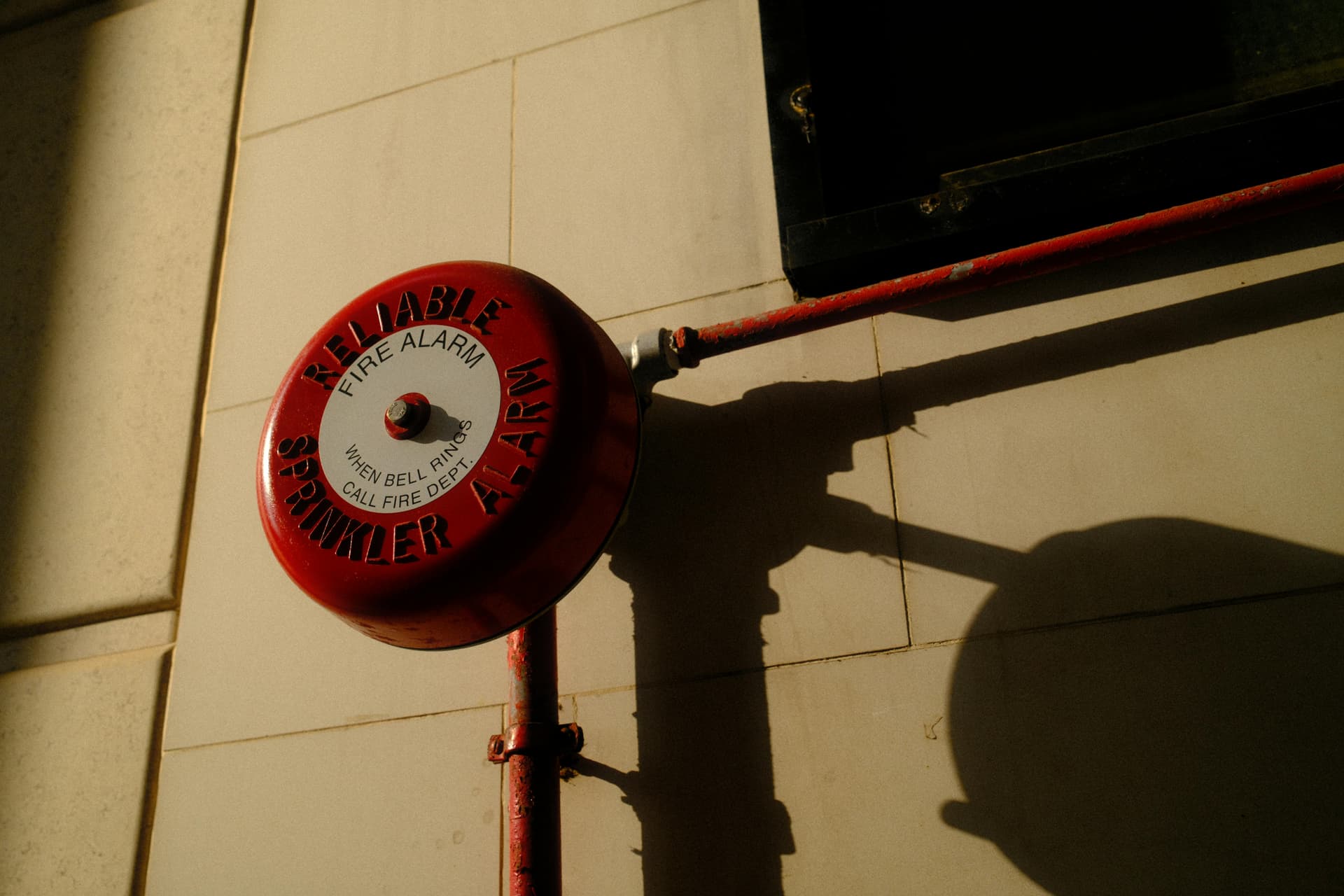 Fire sprinkler alarm bell on a commercial building — the type of protective safeguard that triggers coverage conditions under ISO CP 04 11