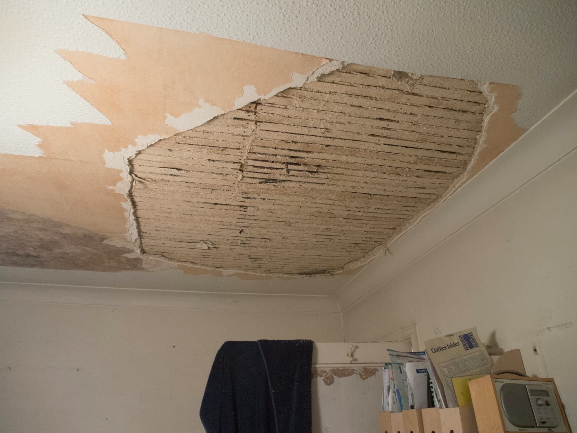 Ceiling exposing lath and plaster with visible water staining illustrating ensuing water damage from a separate covered peril