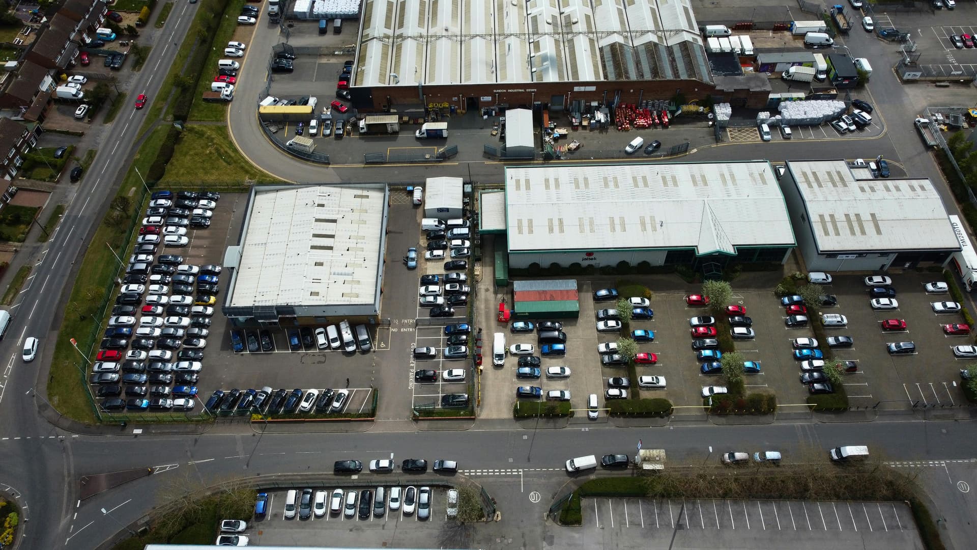 Aerial view of a multi-building commercial industrial complex with warehouses and parking lots — the type of blanket-insured portfolio where margin clause provisions cap per-location recovery